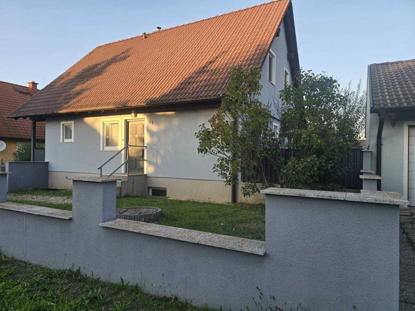 Vorderansicht des Einfamilienhauses mit kleinem Vorgarten und Zugang zum Eingang.