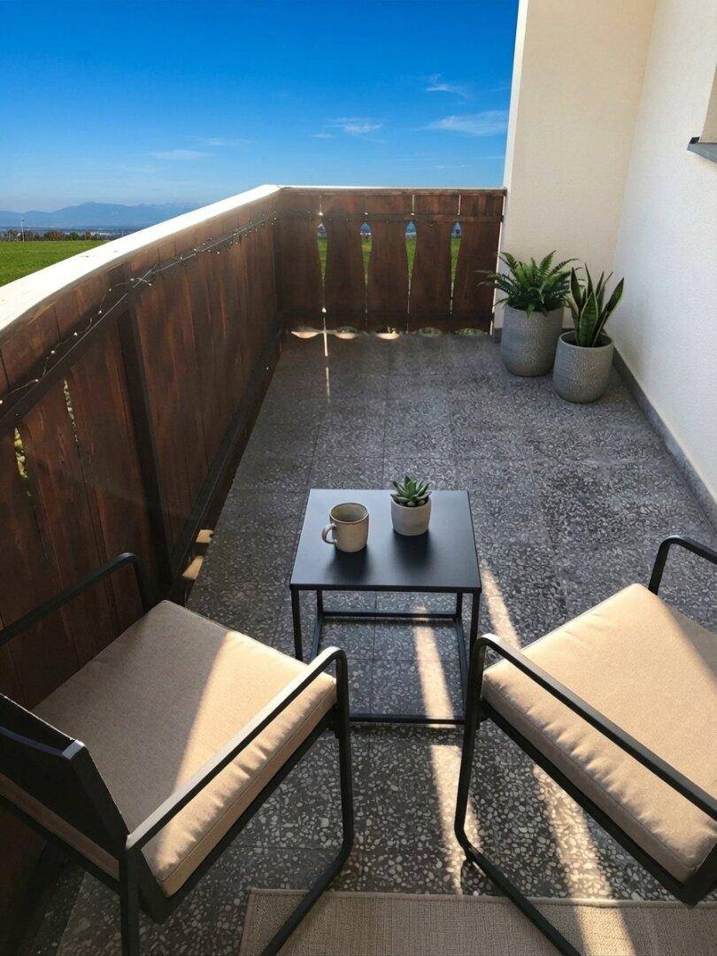 Gemütlicher Balkon mit Sitzgelegenheiten, Pflanzen und weitem Blick in die Ferne.