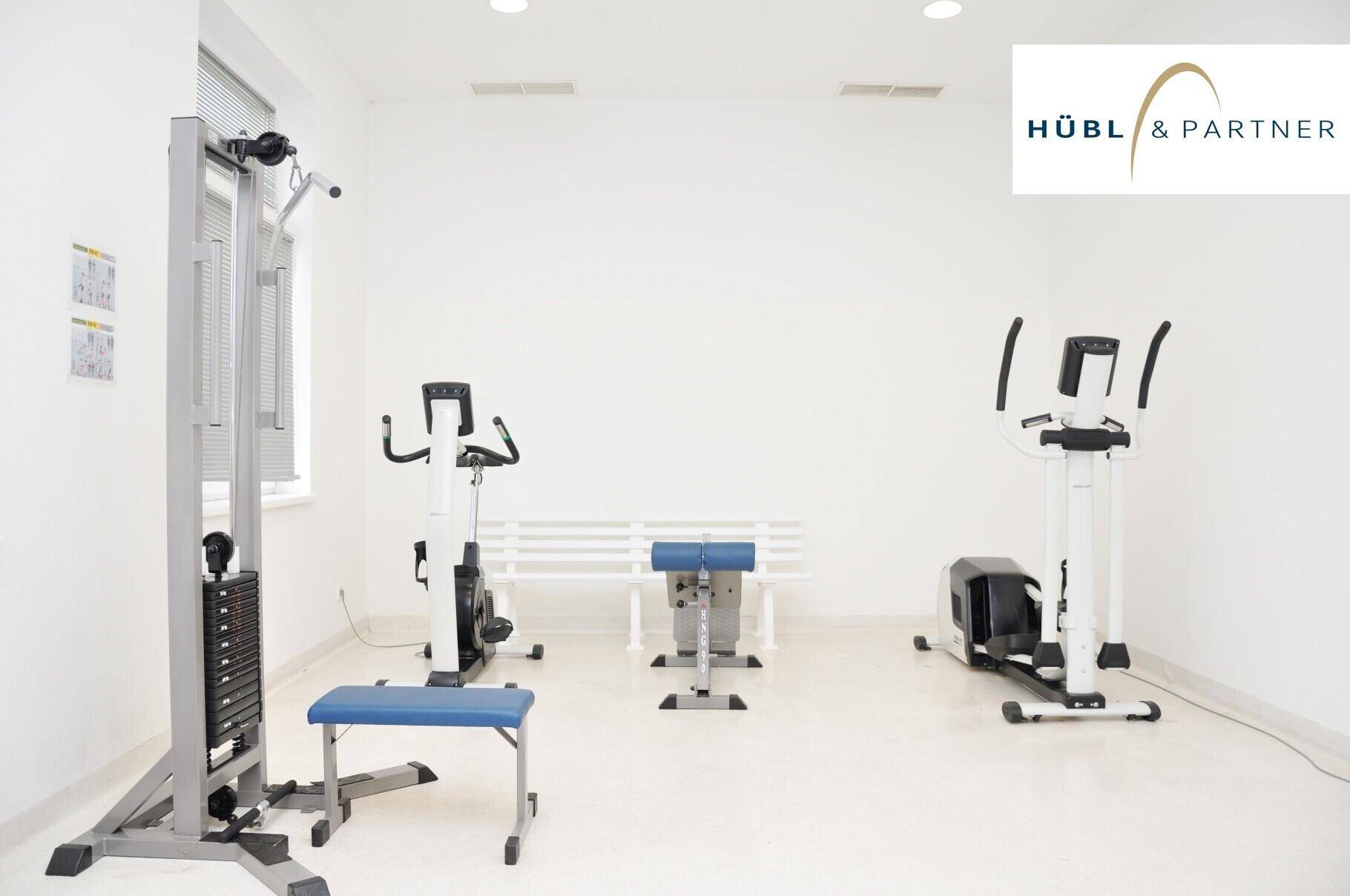 Heller Fitnessraum mit verschiedenen Trainingsgeräten für ein umfassendes Workout.