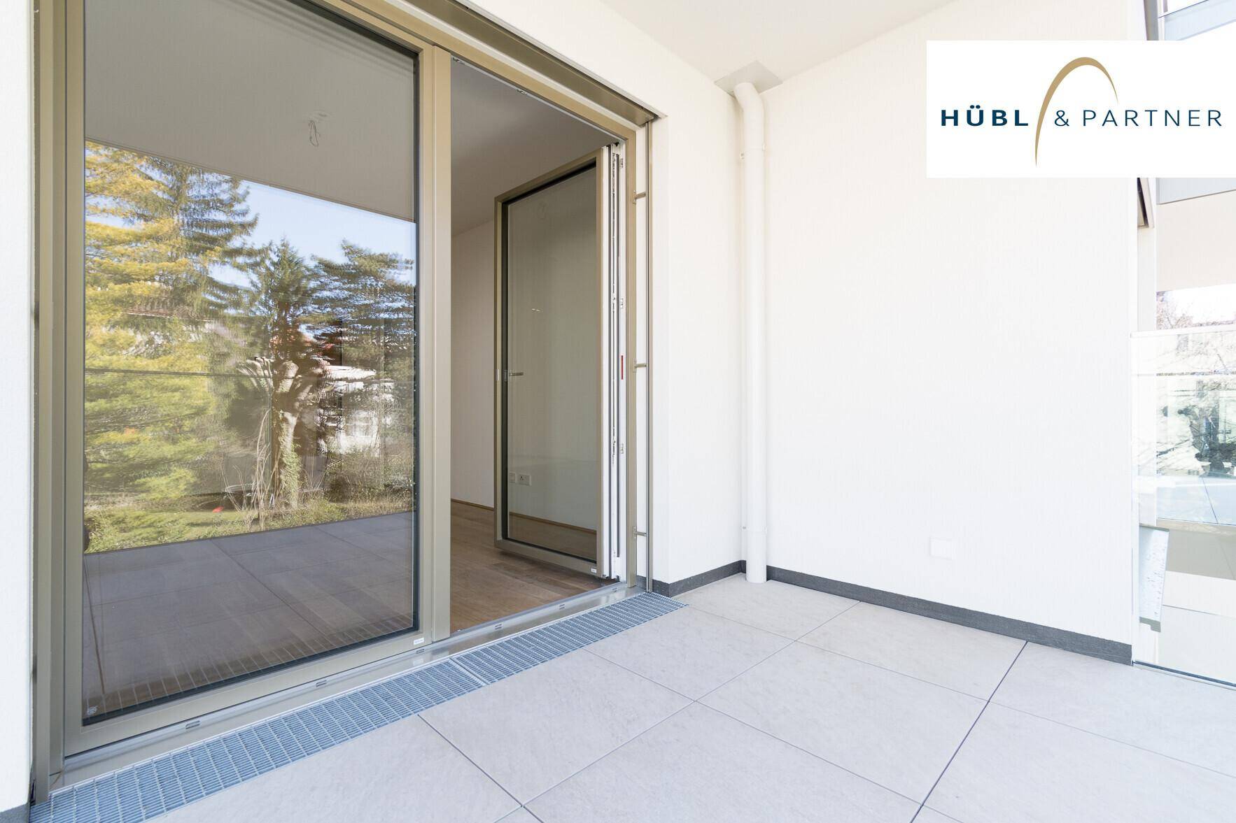 Heller Balkon mit Fliesenboden und Schiebetürzugang zum Innenbereich der Wohnung.