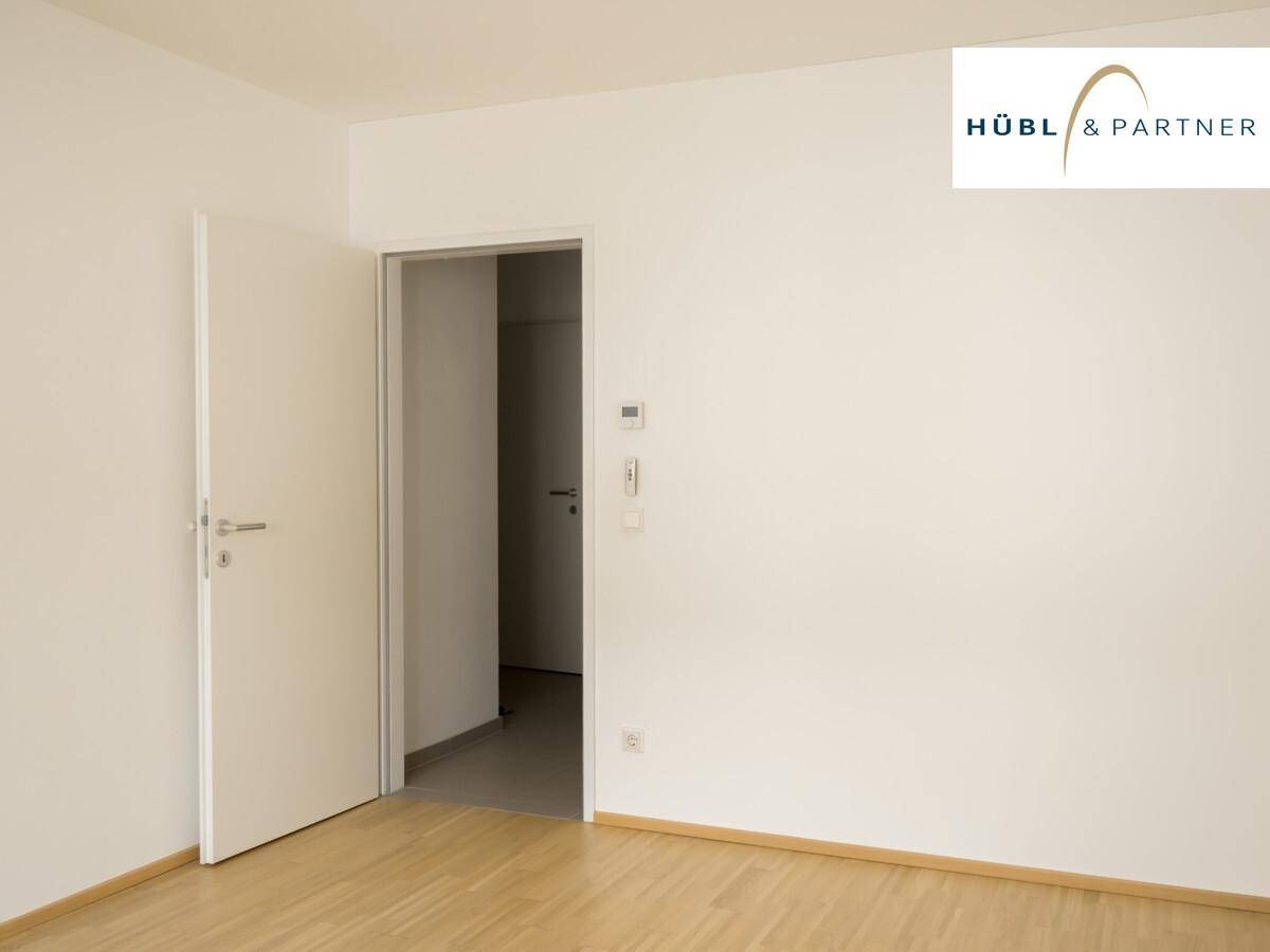 Leerer Raum mit Parkettboden und weiß gestrichenen Wänden, der vielseitig nutzbar ist.
