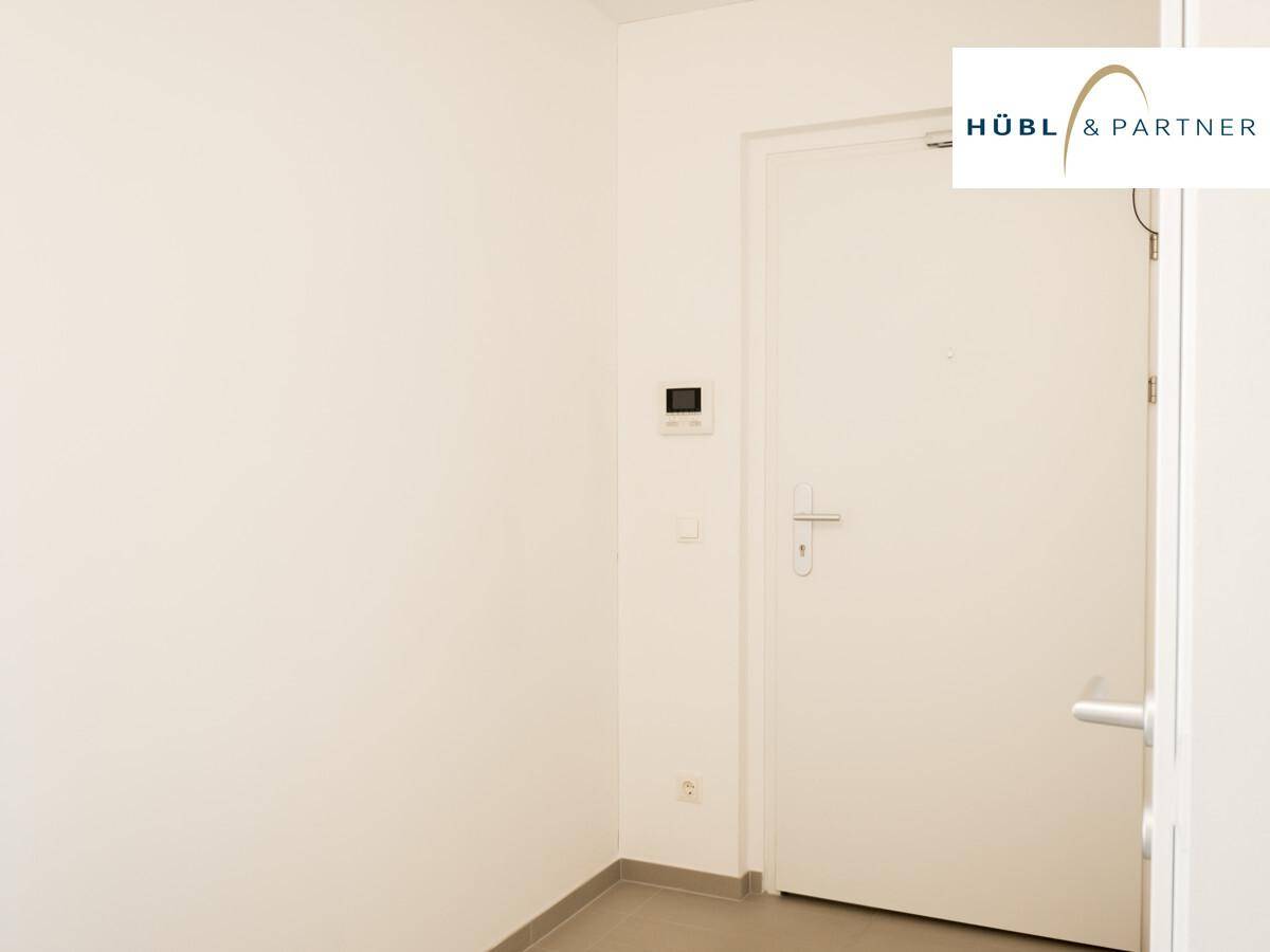 Eingangsbereich mit weißer Wohnungstür und Fliesenboden, der einen sauberen ersten Eindruck vermittelt.