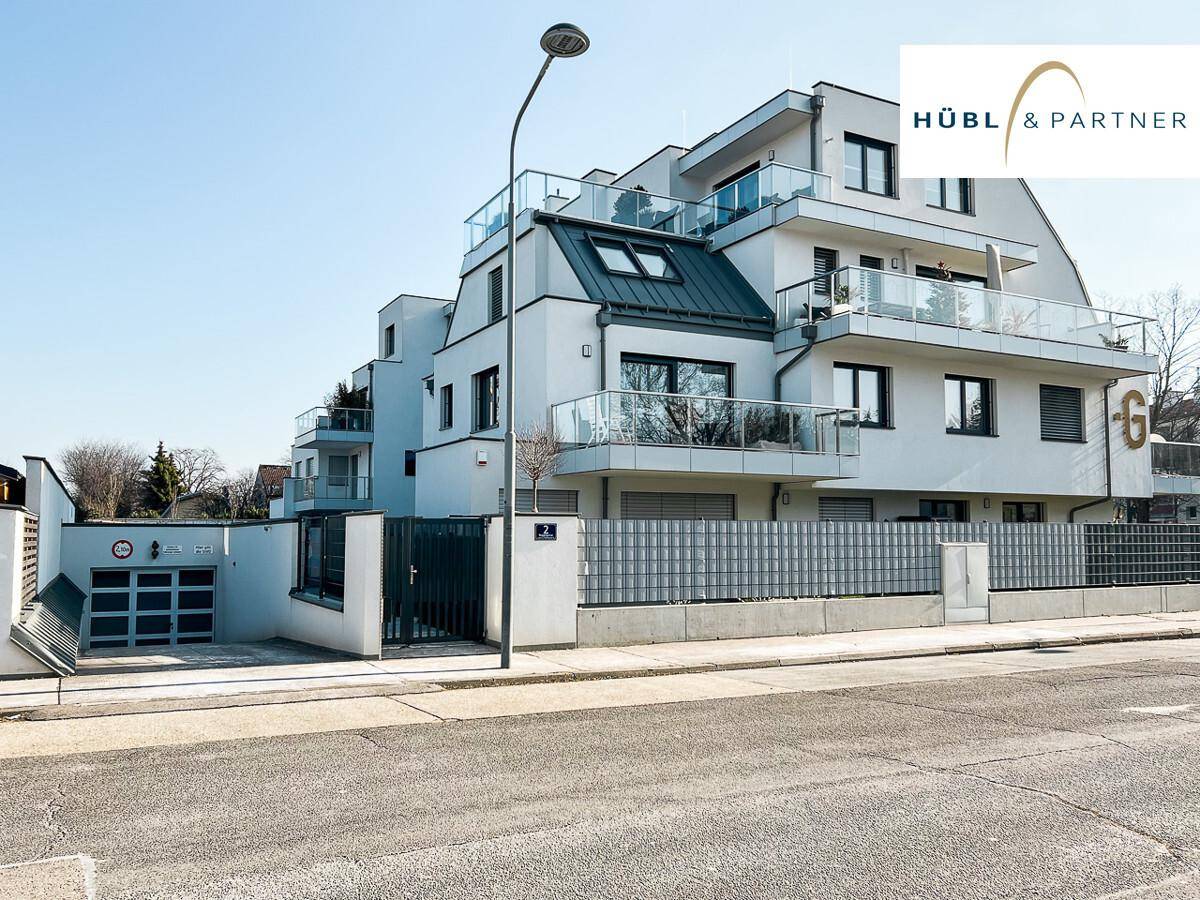 Ansicht der modernen Wohnanlage von der Straße mit Tiefgarageneinfahrt und Eingangsbereich.