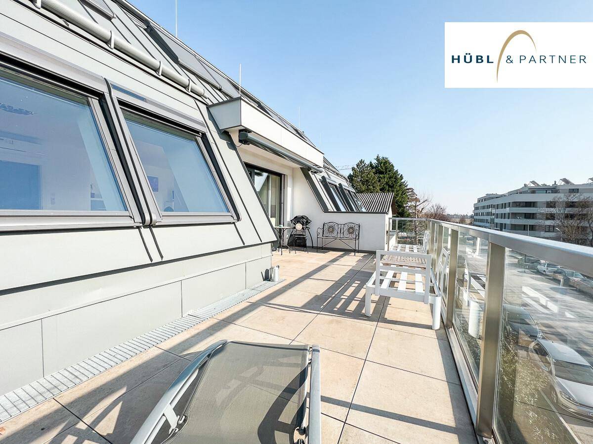 Weitläufige Terrasse mit Blick auf die Dachlandschaft und die umliegenden Gebäude.