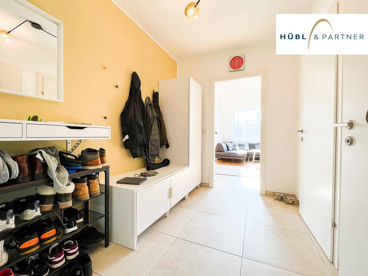 Geräumiger Flur mit heller Gestaltung, Schuhregal und Blick in den Wohnbereich.