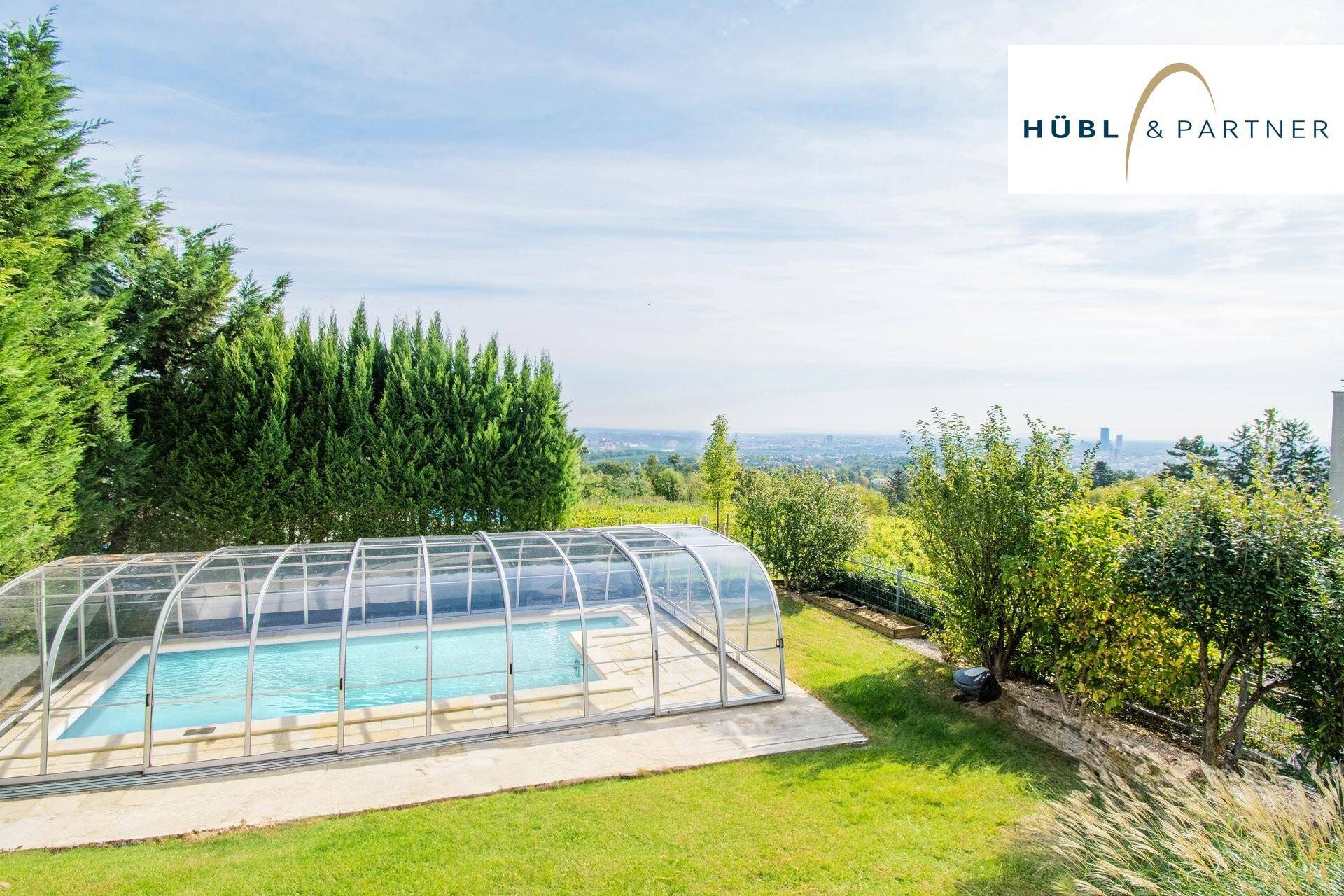 Überdachter Poolbereich im Grünen mit weitem Blick über die Landschaft.