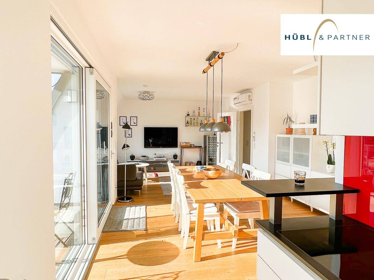 Großzügiger Wohn-Ess-Küchenbereich mit Holzboden, viel Licht und Zugang zur Terrasse.