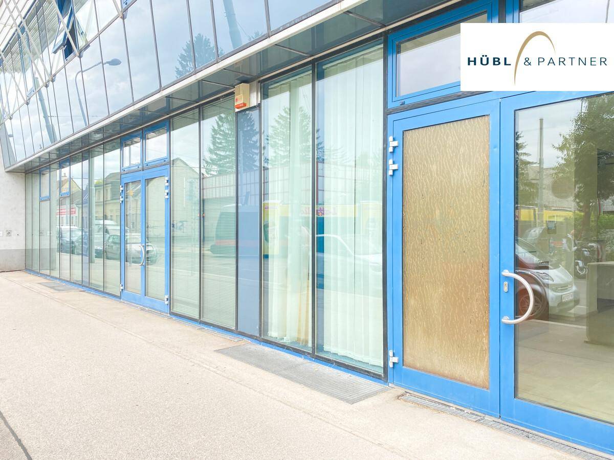 Moderne Glasfassade des Bürogebäudes mit blauen Fensterrahmen und Eingangstüren.