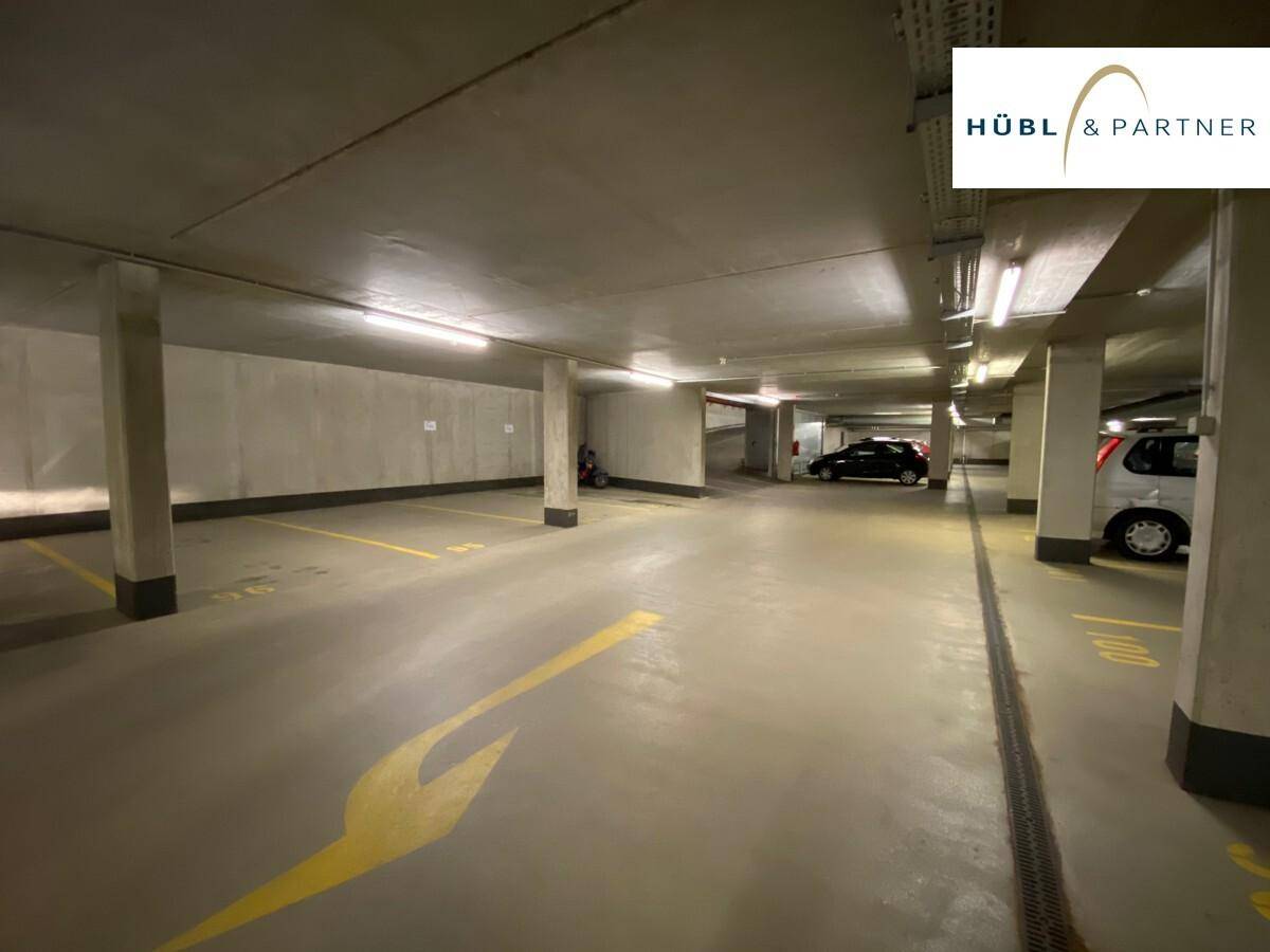 Geräumige Tiefgarage mit mehreren Stellplätzen, Betonkonstruktion und Beleuchtung.