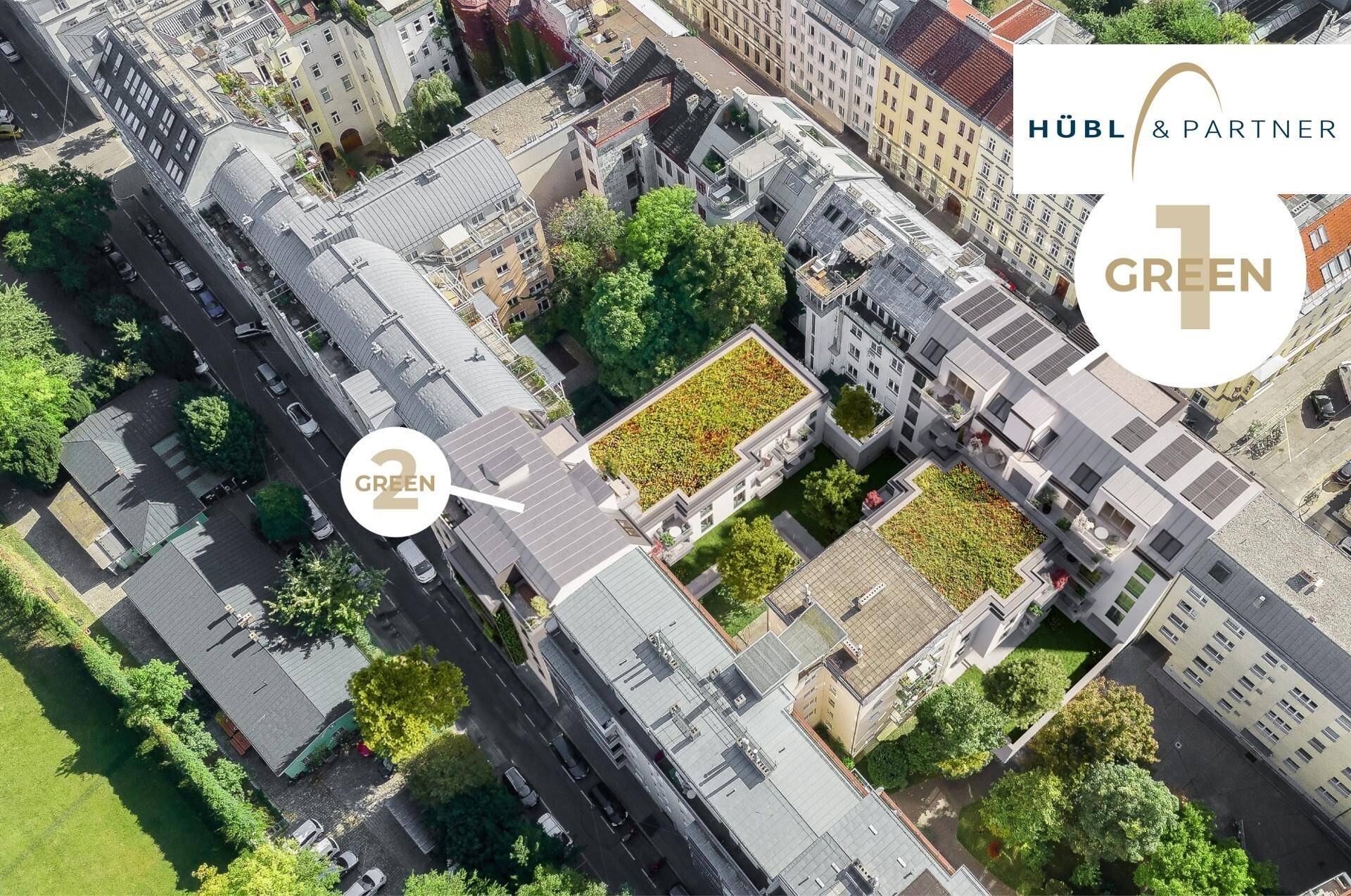Luftaufnahme eines modernen Wohnkomplexes mit begrünten Dächern und umliegender Stadtlandschaft.