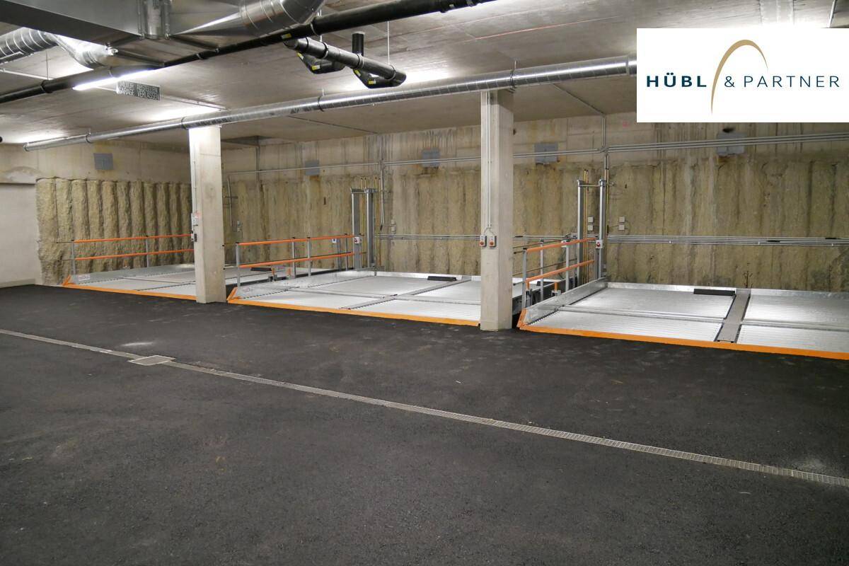 Moderne Tiefgarage mit mehreren Parkliftsystemen und Betonwänden für effizientes Parken.