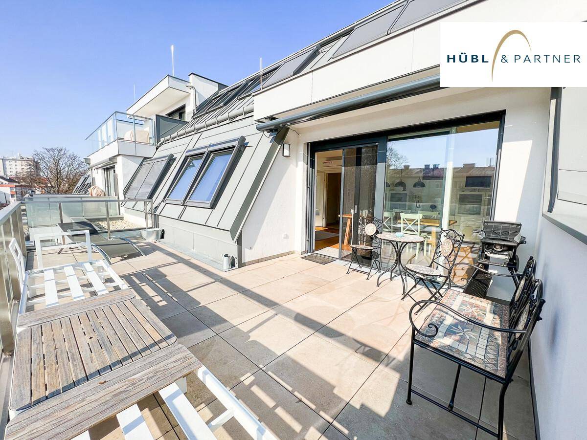 Geräumige Terrasse mit direktem Zugang zum Innenbereich und modernen Außenmöbeln.