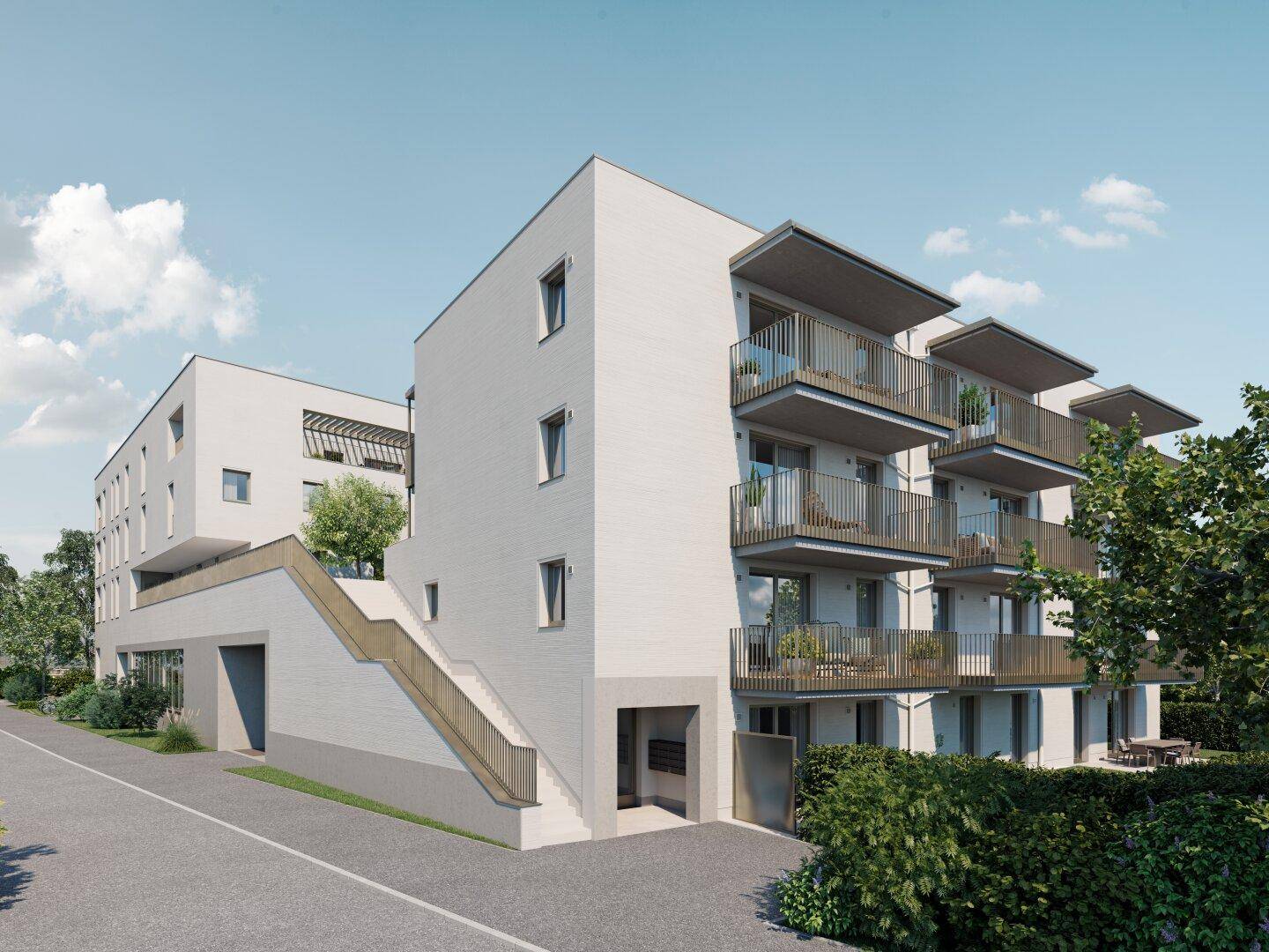 Moderne Wohnanlage mit mehreren Balkonen und Außentreppe zum Eingang.