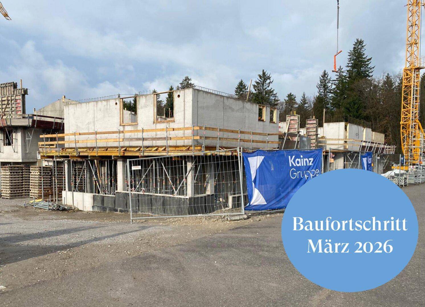 Nahaufnahme einer Baustelle mit im Rohbau befindlichen Gebäuden und Holzschalungen.