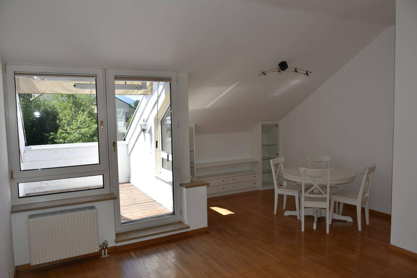 Geräumiger Wohnbereich mit Esstisch, Dachschrägen und direktem Zugang zur sonnigen Terrasse.