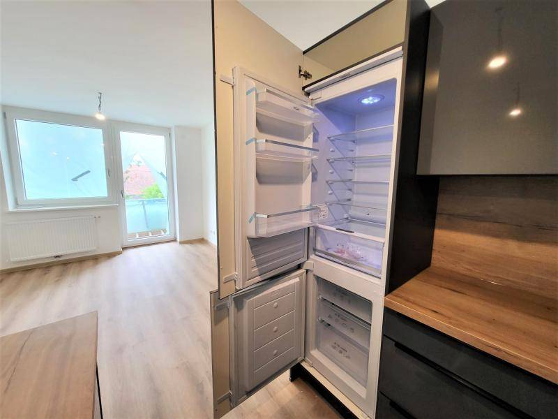 Integrierter Kühlschrank in der modernen Küche mit Blick auf den hellen Wohnbereich.