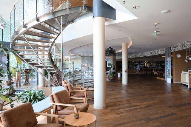 Geräumiger Loungebereich mit eleganter Wendeltreppe und Holzboden.