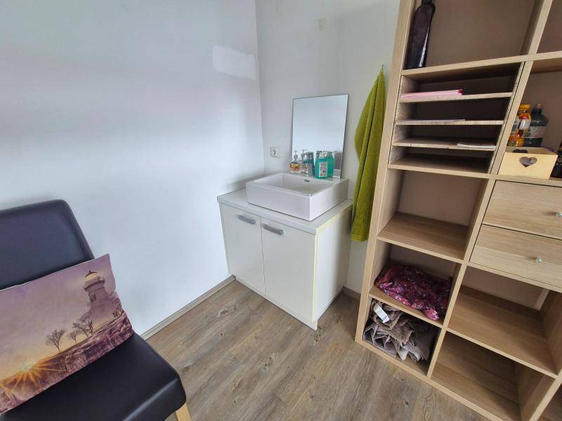 Detailansicht des Behandlungsraums mit einem modernen Waschbecken auf einem weißen Unterschrank.