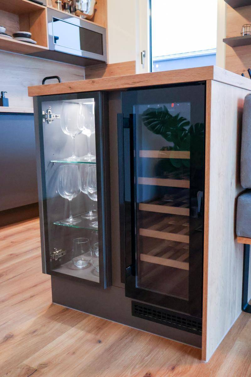 Integrierter Weinkühler und Glasvitrine in der Kücheninsel, perfekt für Unterhaltung.