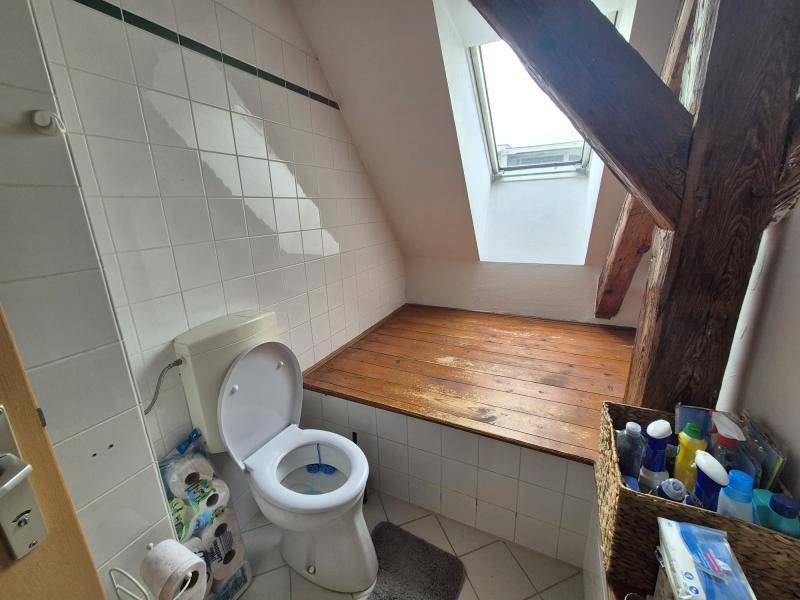 Separate Toilette mit WC, Waschbecken und Dachfenster, teilweise gefliest, bietet Privatsphäre.