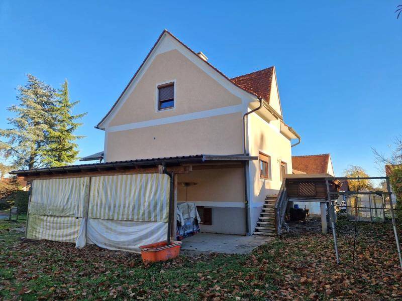 Rückansicht des Hauses mit einem überdachten Bereich und einem erhöhten Zugang.