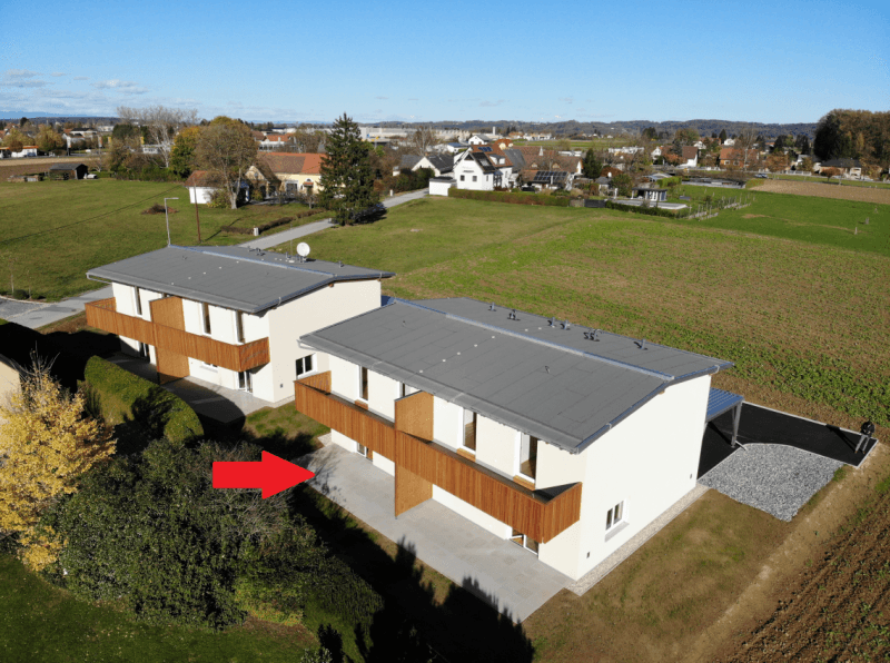 Luftaufnahme von zwei modernen Doppelhäusern in ländlicher Umgebung mit viel Grün.
