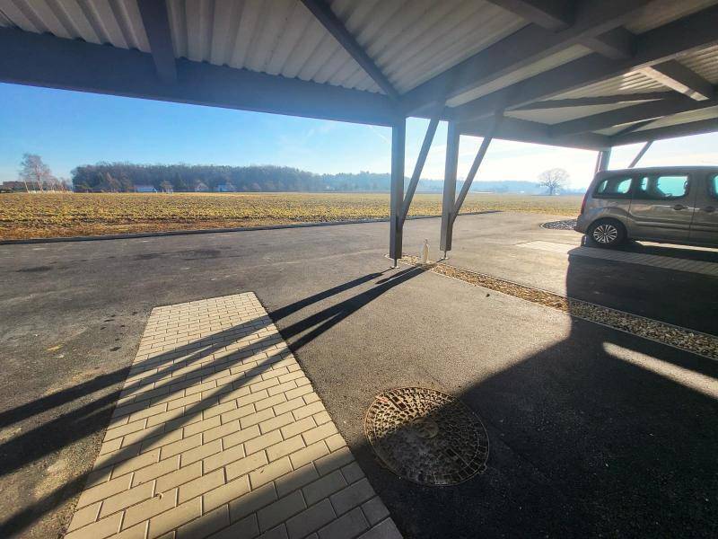 Carport mit Blick auf die weite Landschaft und ein geparktes Fahrzeug.