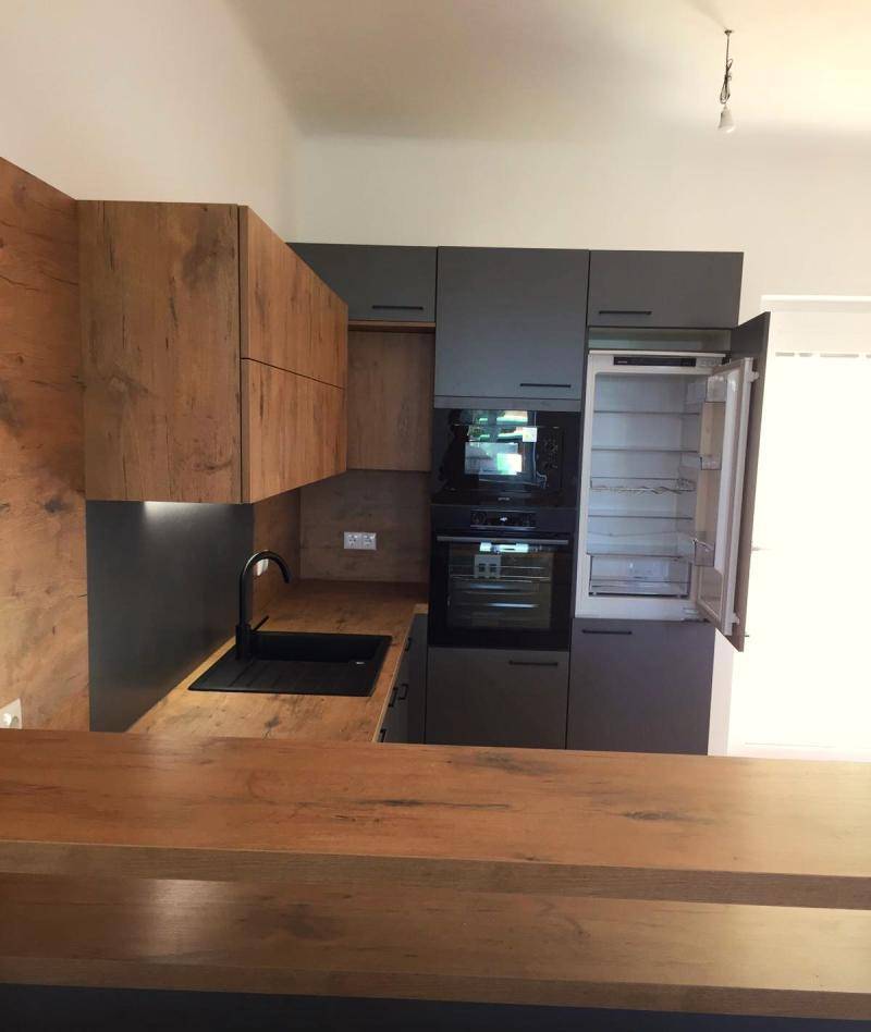 Moderne Küche mit integriertem Kühlschrank, Backofen und Mikrowelle, alles in einem Design.