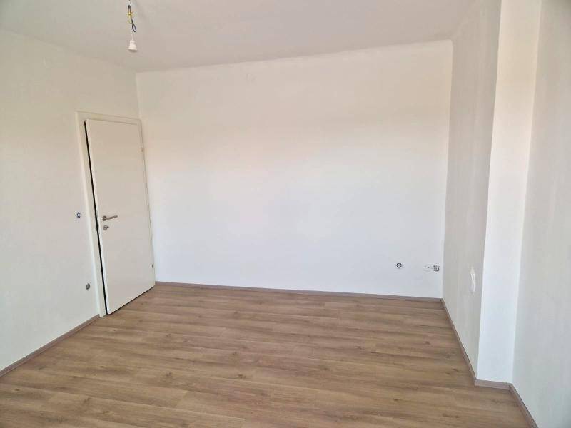 Leeres Zimmer mit weiß gestrichenen Wänden und neuem Laminatboden, bereit zur individuellen Gestaltung.