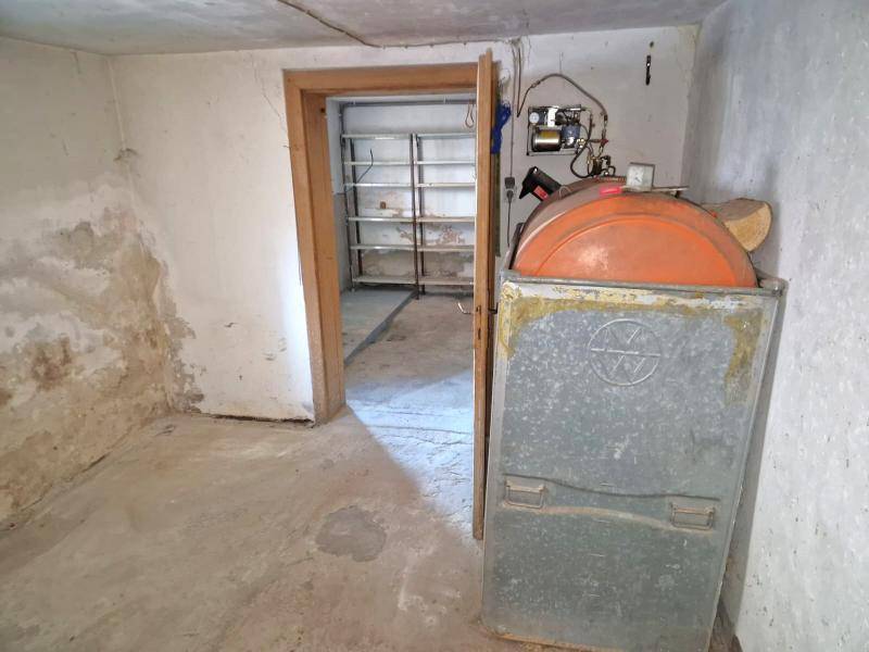 Kellerraum mit Heizöltank und Regalen, ideal als Abstellraum nutzbar.