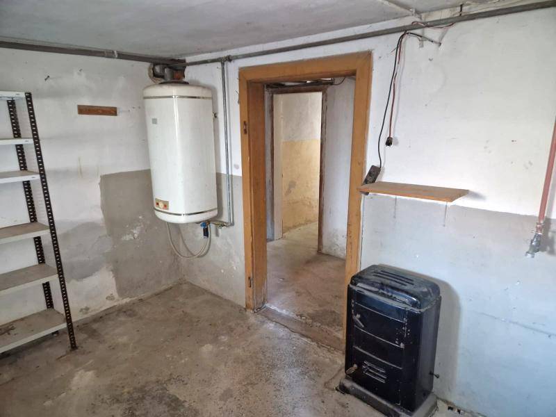 Kellerraum mit Warmwasserboiler und kleinem Ofen, ideal als Waschküche oder Abstellraum.
