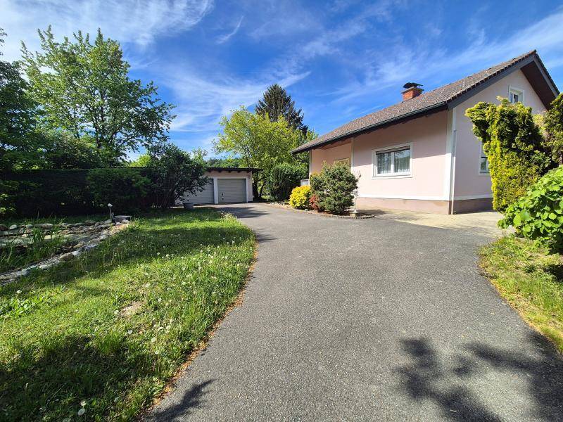 Lange Auffahrt zum Haus mit angrenzendem Gartenbereich und Blick auf die separate Garage.