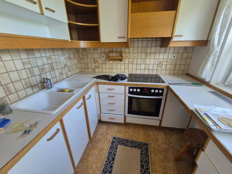 Funktionale Küche mit weißen Schränken, integriertem Backofen und Kochfeld, bereit zur Nutzung.