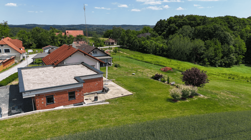 Weitläufige Ansicht des Hauses mit Flachdachanbau und umliegender ländlicher Landschaft.