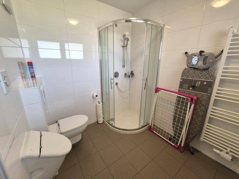 Helles Badezimmer mit Duschkabine, Toilette, Bidet und einem praktischen Handtuchheizkörper.