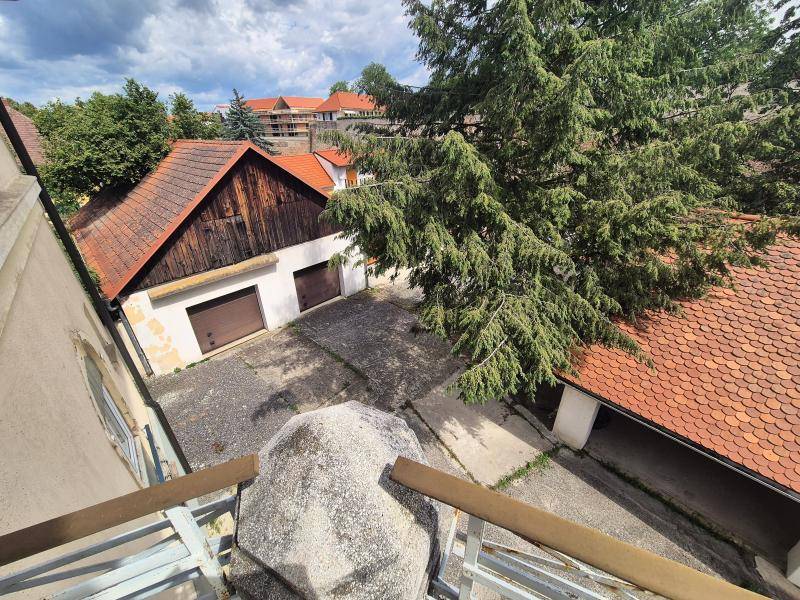Blick auf Garagen und einen Hofbereich mit Bäumen und einem weiteren Gebäude.