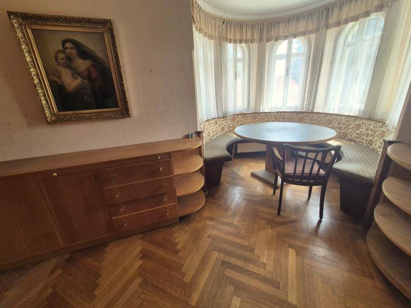 Gemütlicher Essbereich mit runder Sitzbank, Holztisch und Fischgrätparkett.