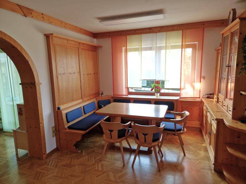 Gemütlicher Essbereich mit Holztisch, Eckbank und Blick durch das Fenster.