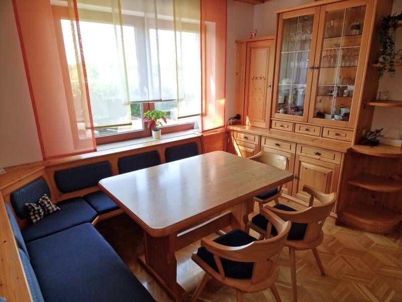 Rustikaler Essbereich mit Holztisch, Eckbank und Vitrinenschrank.