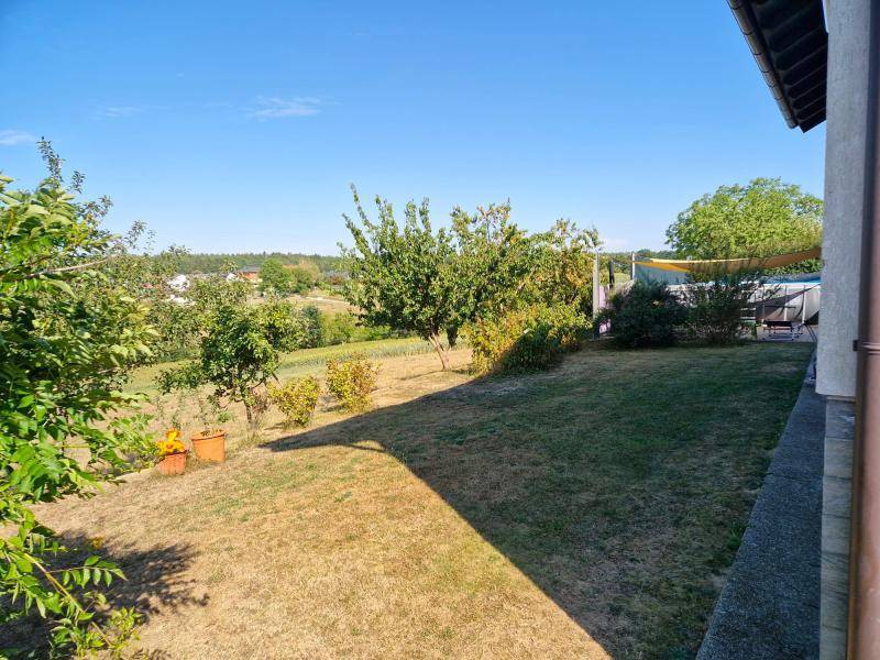 Großer Garten mit Rasenfläche, Obstbäumen und weitem Blick in die Natur.
