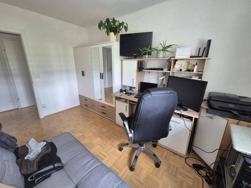 Funktionales Arbeitszimmer mit großem Schreibtisch, mehreren Monitoren und Stauraum.