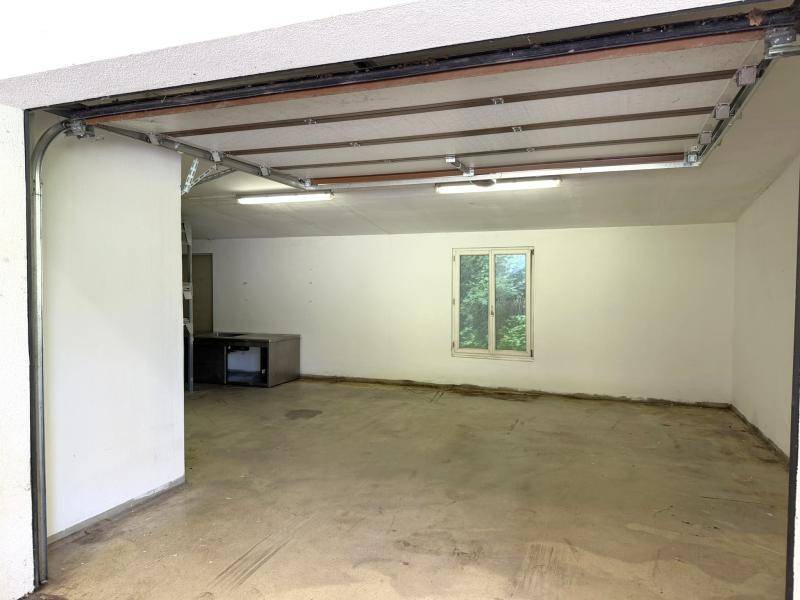 Geräumige Garage mit Betonboden, Fenster und Tageslicht, ideal als Abstellraum.