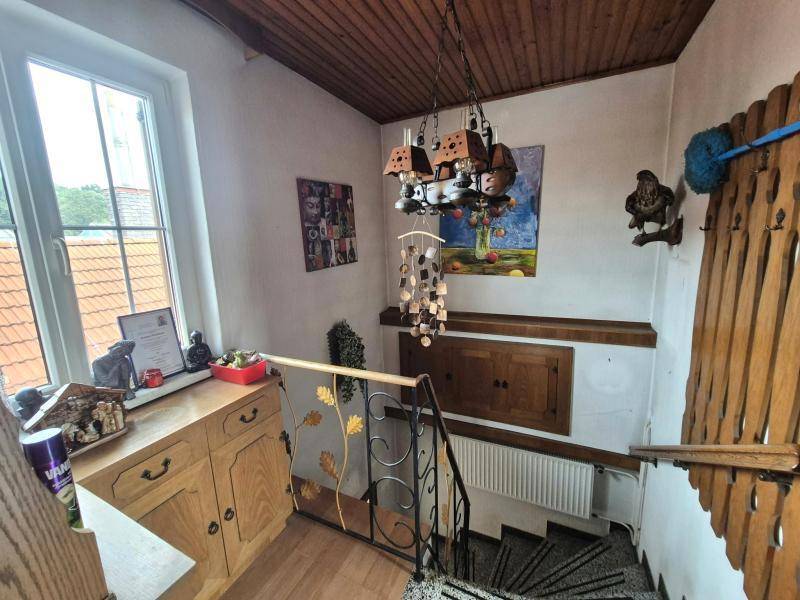 Treppenabsatz mit Holzvertäfelung, Fenster und traditioneller Dekoration, bietet natürlichen Lichteinfall.