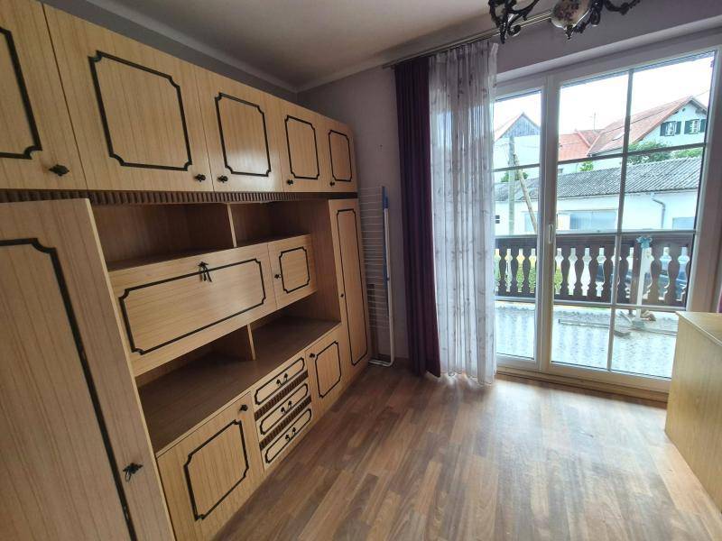 Schlafzimmer mit Einbauschränken aus Holz und Zugang zu einem Balkon mit viel Tageslicht.