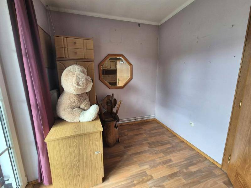 Helles Zimmer mit Laminatboden und einem großen Fenster, ideal als Schlaf- oder Gästezimmer.