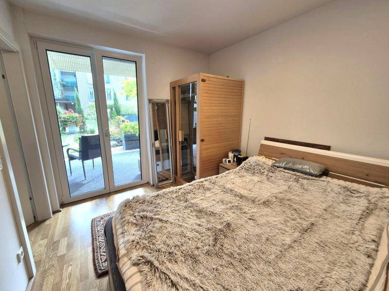Schlafzimmer mit Doppelbett, privater Infrarotsauna und direktem Zugang zur Terrasse.