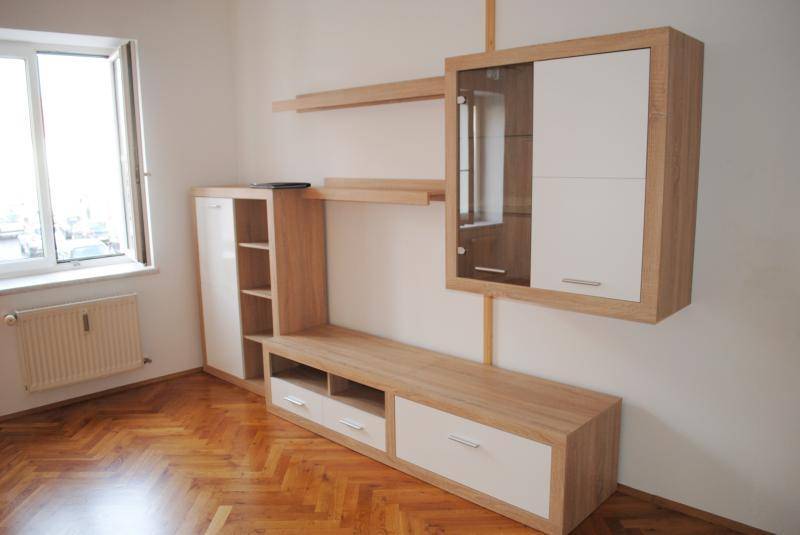 Modern eingerichtetes Wohnzimmer mit hellem Holzmöbeln, Fenster und Fischgrätparkettboden.