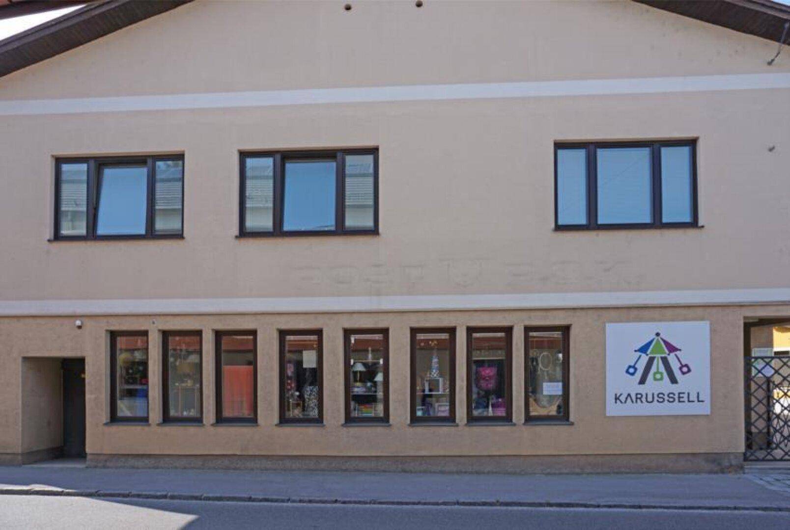Fassade des Gebäudes mit Schaufenstern im Erdgeschoss und Fenstern der oberen Etagen.