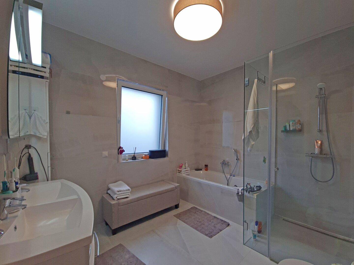 Modernes Badezimmer mit Doppelwaschbecken, Badewanne und separater Dusche.