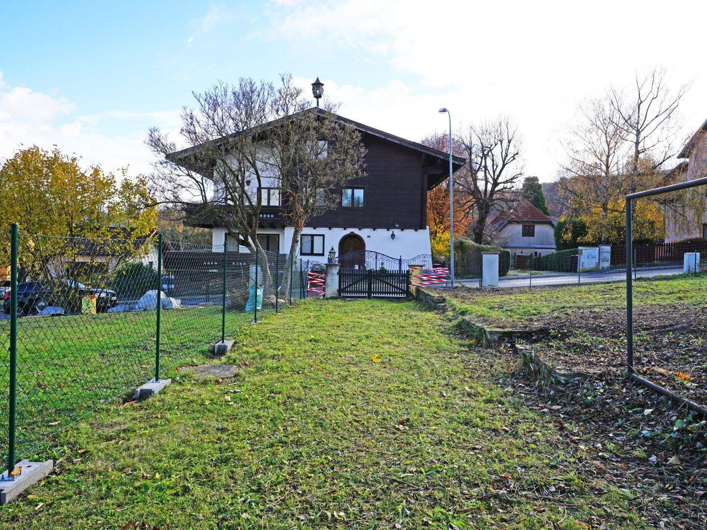 Blick auf das charmante Haus mit traditioneller Architektur und einem Vorgarten, umgeben von einem Zaun.
